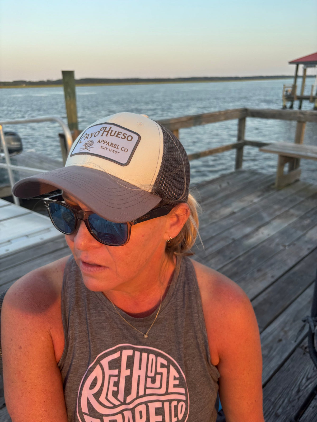 Classic Logo gray patch trucker hat on a dock